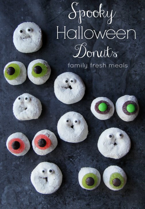 powdered donuts on a table with candy eyes on them