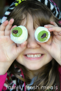 Child holding donut eyes up to face
