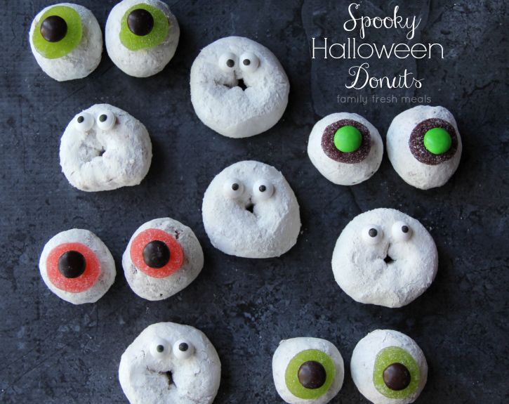 powdered donuts on a table with candy eyes on them