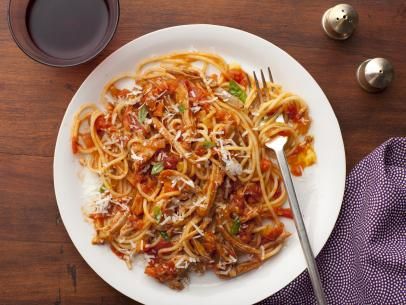 Turkey Bolognese mixed in with noodles on a plate with a fork