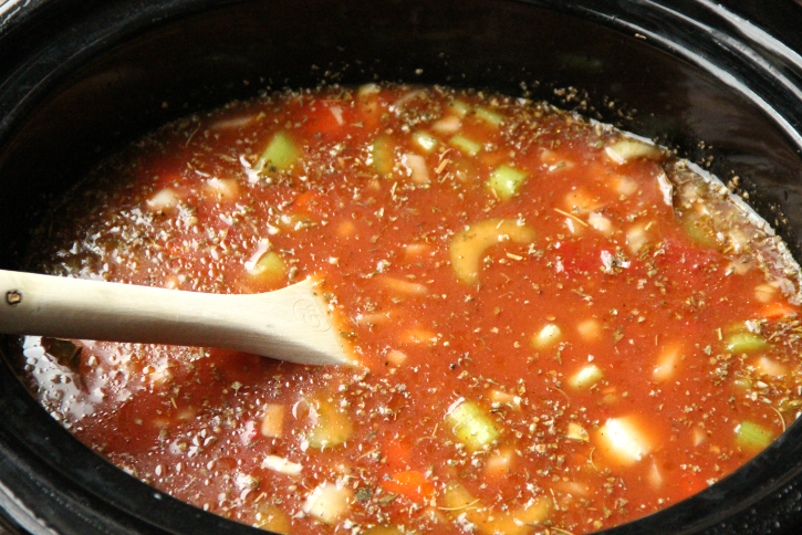 The Best Crockpot Minestrone Soup - Stirring ingredients in slow-cooker