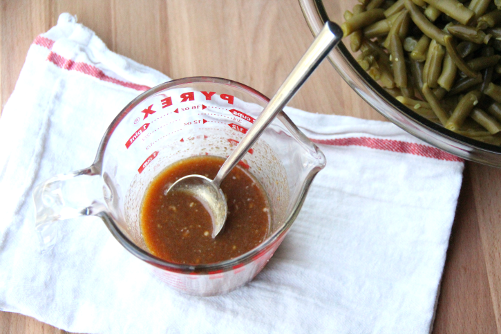 green bean sauce in a measure cup with a spoon