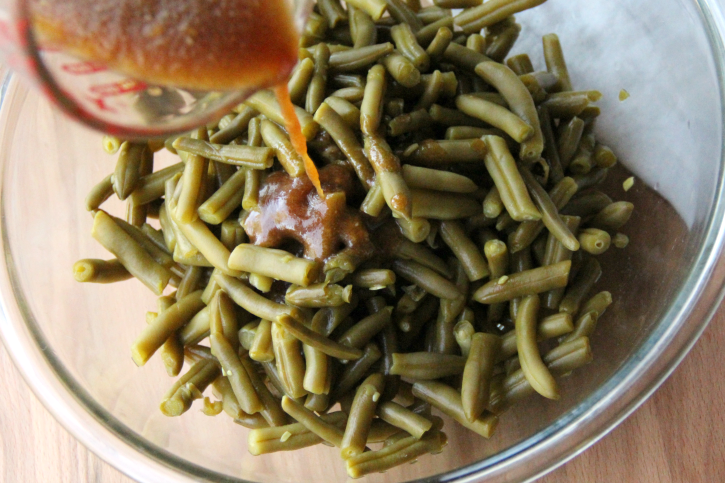 pouring sauce over green beans