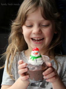 Child smiling while holding a Snowman Cup