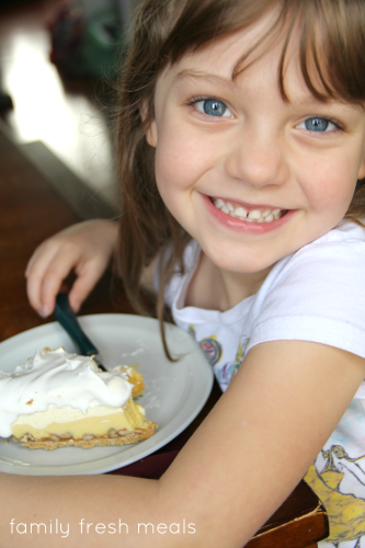 Child sitting with a piece of Triple Layer Eggnog Pie, smiling