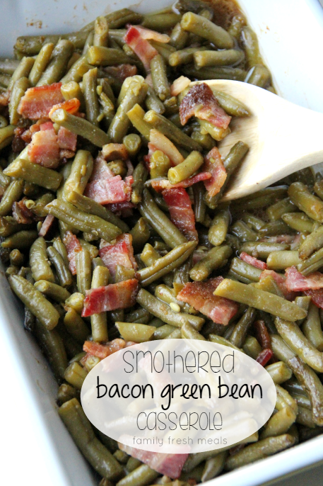 Smothered Bacon Green Bean Casserole in a casserole dish with a wooden spoon