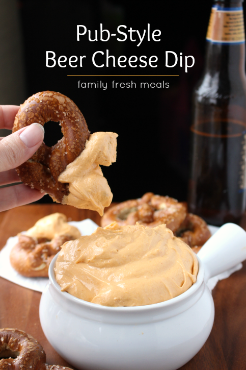 Pub Style Beer Cheese Dip with a pretzel dipping into it