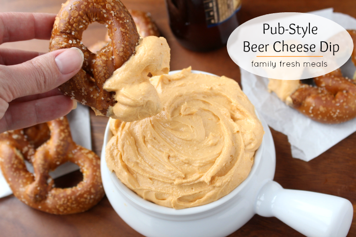 Pub Style Beer Cheese Dip with pretzel dipping into it
