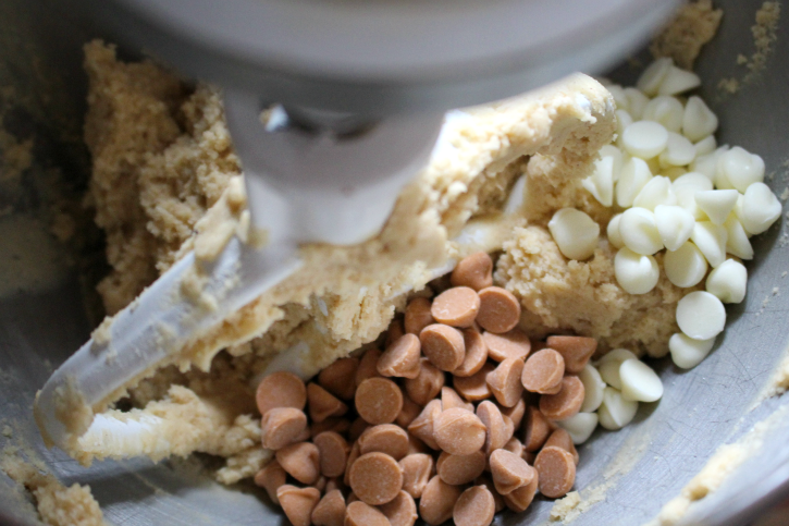 adding chocolate chips and butterscotch chips to dough