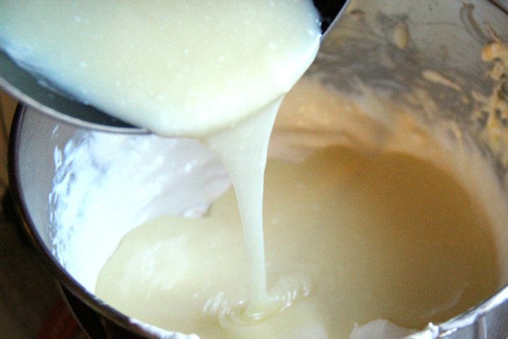 pouring white chocolate mixture into mixing bowl