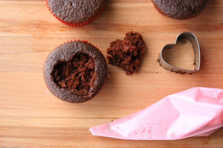 Cutting a heart shape with a cookie cutter out of cupcake