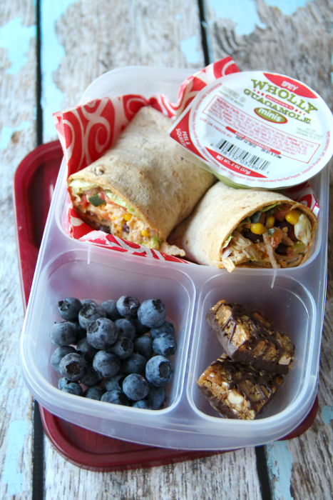 Sandwich wrap packed with a container of guacamole, blueberries and a granola bar