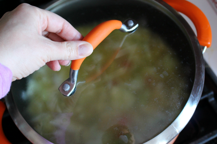 placing lid on soup pot