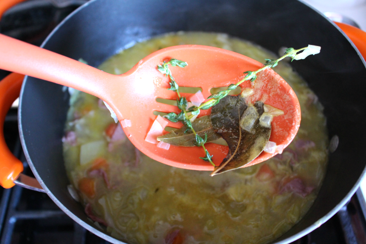 removing herbs from soup pot with a spoon