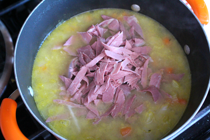 adding sliced corned beef into soup