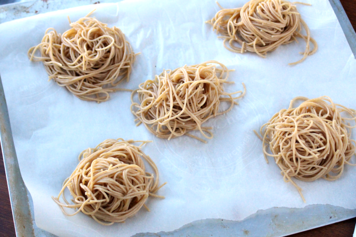 5 piles of pasta on a parchment paper lined baking sheet