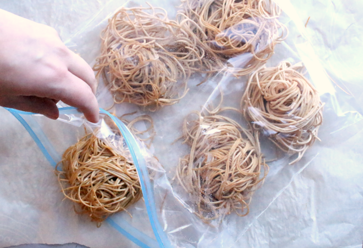 placing frozen piles of pasta into a ziplock bag