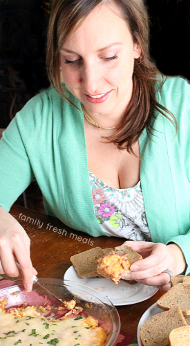 Woman scooping some dip on to a small toast