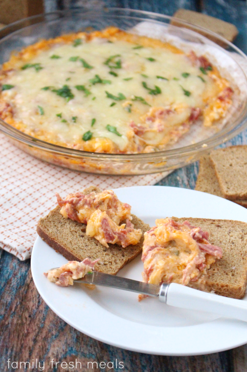 Reuben Dip served with small toasts on a white plate