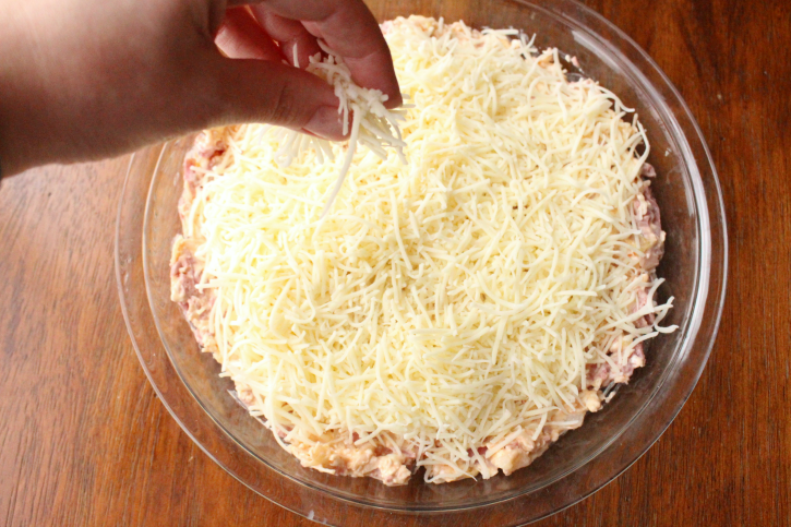 Reuben Dip - Sprinkling cheese on top of dip 