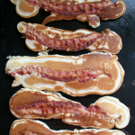 cooked bacon pancakes on cooking griddle