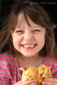 Child smiling while holding crockpot chicken sandwich