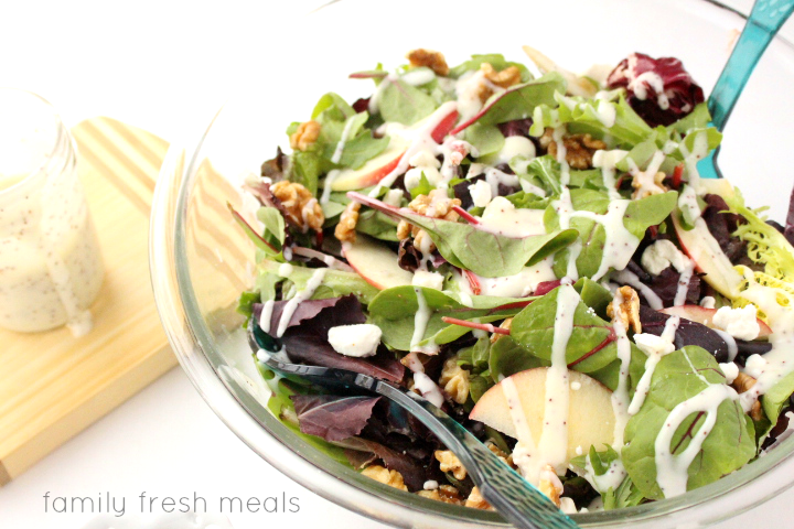 the best homemade poppy seed dressing drizzled on a salad in a glass bowl