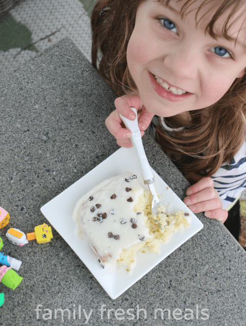 Child sitting at a table eating a piece of Cannoli Poke Cat