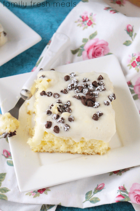 Piece of Cannoli Poke Cake Enjoy on a white plate