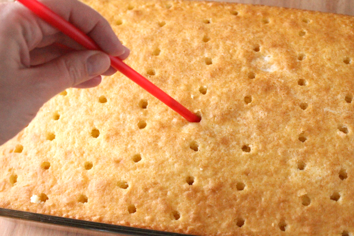 poking holes in the cake with a straw