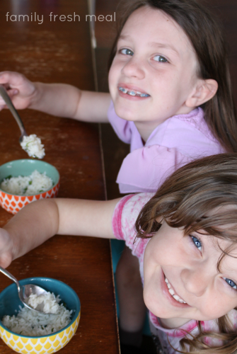 Two children sitting with bowls of Copycat Chipotle Cilantro Lime Rice