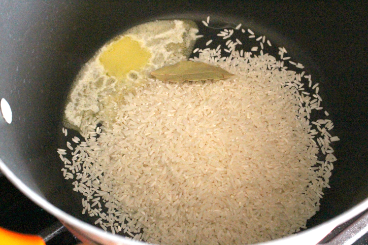 rice in a pot with butter and bay leaf