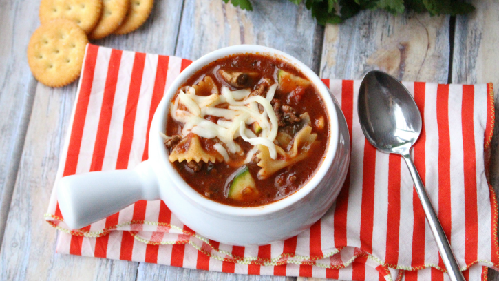 Hearty Slow Cooker Lasagna Soup in a white bowl with a spoon next to it