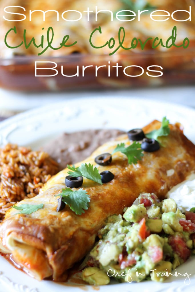 Smothered Chile Colorado Burritos on a plate with rice, beans, guacamole and sour cream