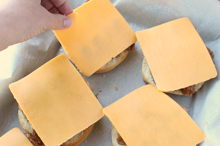 Adding cheese slices to top of open faced sandwiches