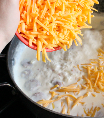 adding shredded cheese to the pot
