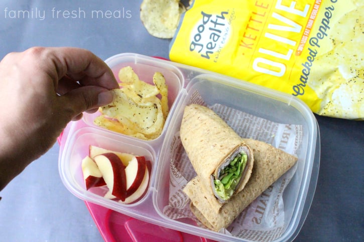 Cracked Pepper Chips , sandwich wrap and apples slices in a lunchbox