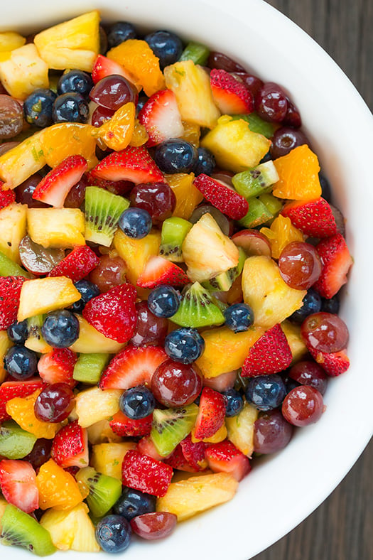 honey lime rainbow fruit salad in a white bowl