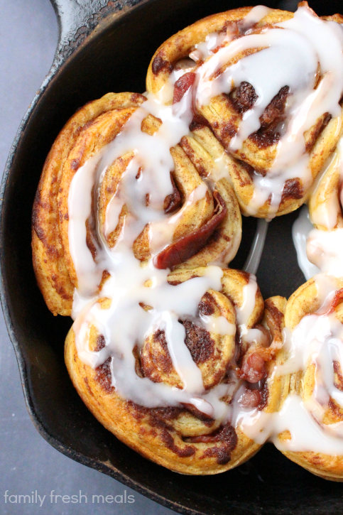 Bacon Wrapped Cinnamon Rolls in a cast iron skillet