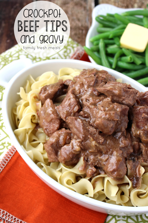 Easy Crockpot Beef Tips and Gravy served over noodles in a serving dish