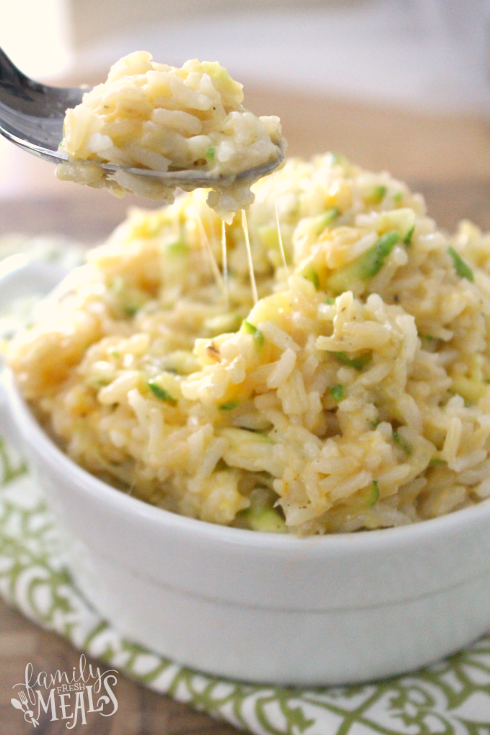 One Pot Cheesy Zucchini Rice in a bowl with a spoon scooping some up.