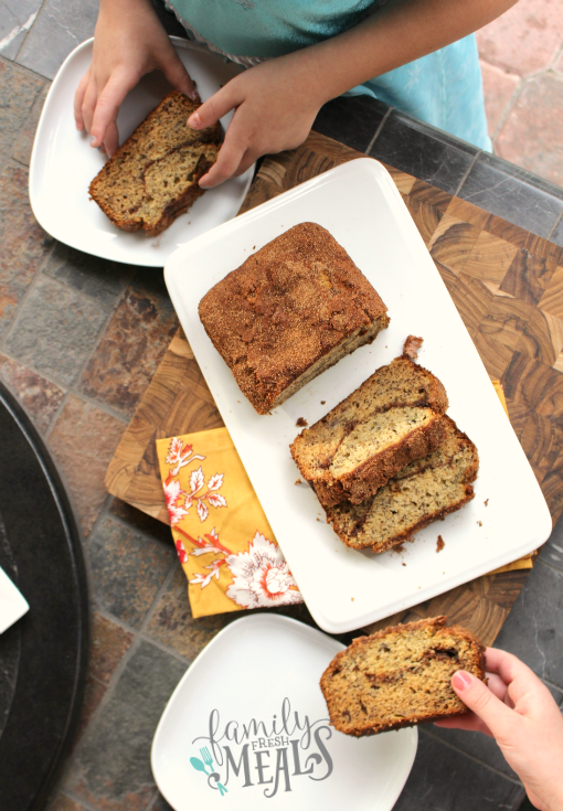 Cinnamon Swirl Banana Bread slices on a plate, with people taking a slice