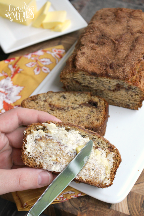 Spreading butter on a slice of Cinnamon Swirl Banana Bread