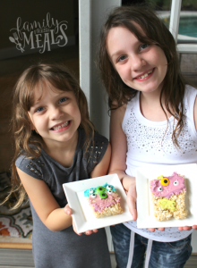 2 children holding Easy Halloween Monster Rice Krispie Treats on plates