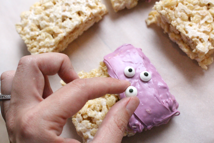 Placing candy eyes on Rice Krispie Treats 