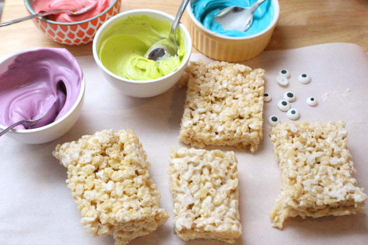 Rice Krispie Treats, melted chocolate and candy eyes on parchment paper