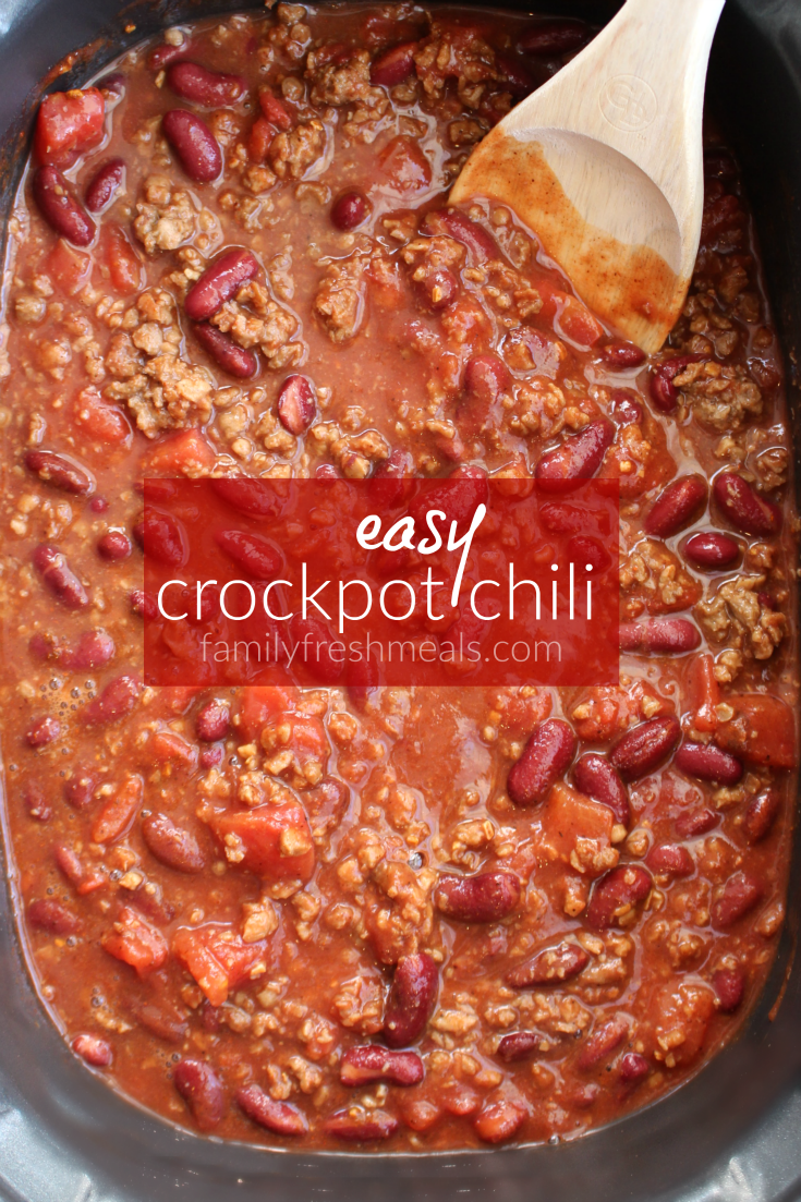 Easy Crockpot Chili in a slow cooker with a wooden spoon