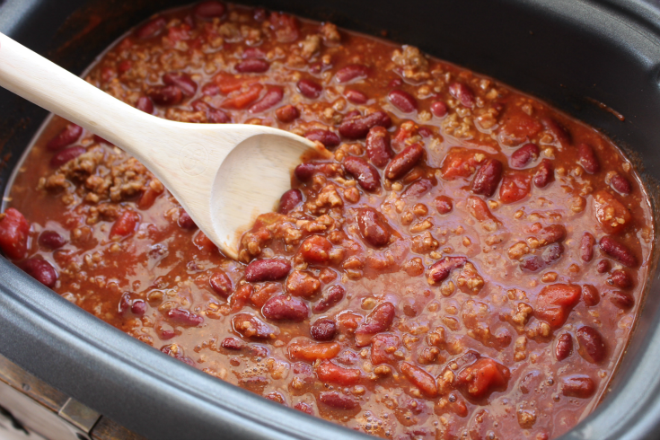 Easy Crockpot Chili - Chili in a crockpot and a wooden spoon stirring