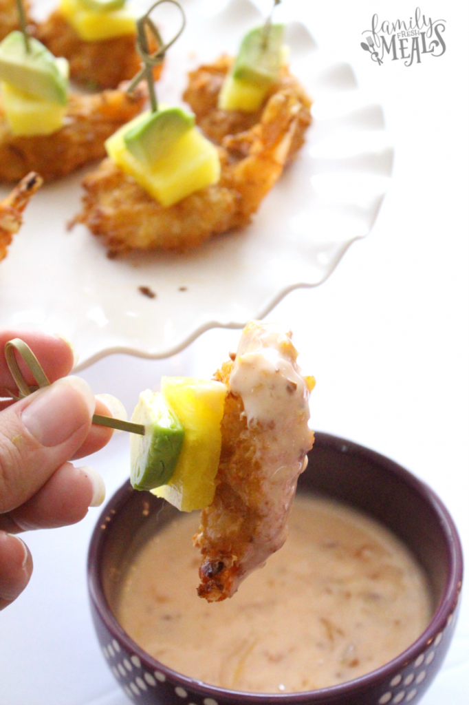 Dipping a Tropical Coconut Shrimp Bite into cream sauce