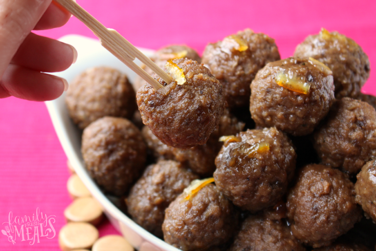 Zesty Crockpot Cranberry Meatballs in a serving bowl, with a food pick in one of the meatballs
